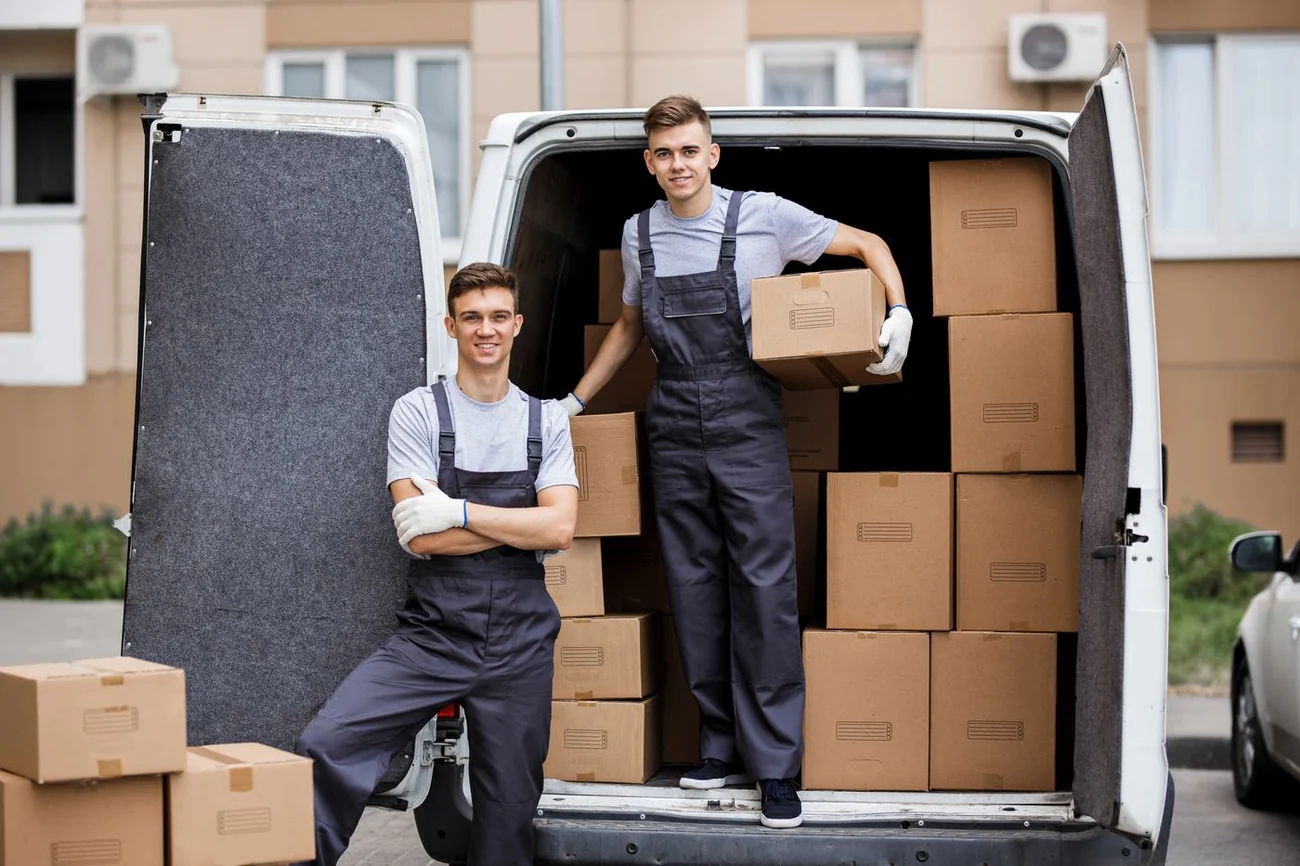Glückliches Paar zieht mit Umzugskartons in eine helle neue Wohnung ein